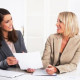 Women discussing bookkeeping while smiling