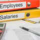 Employee binders with grey calculator, payroll paperwork
