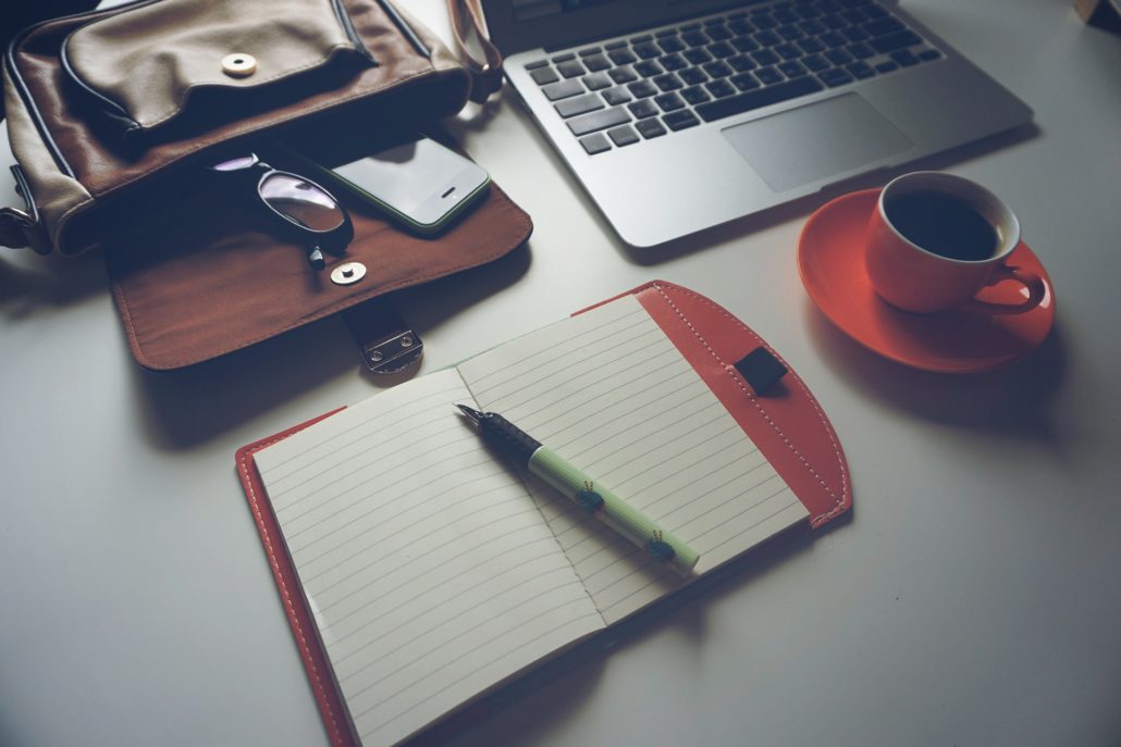 office desktop with laptop notebook coffee and bag