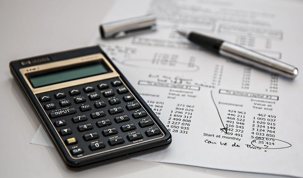 black calculator and silver pen on mathematical sheet